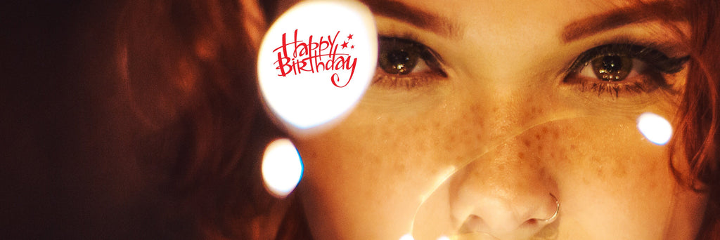 Frau mit ausdrucksstarken Augen und süßen Sommersprossen neben dem Schriftzug Happy Birthday.