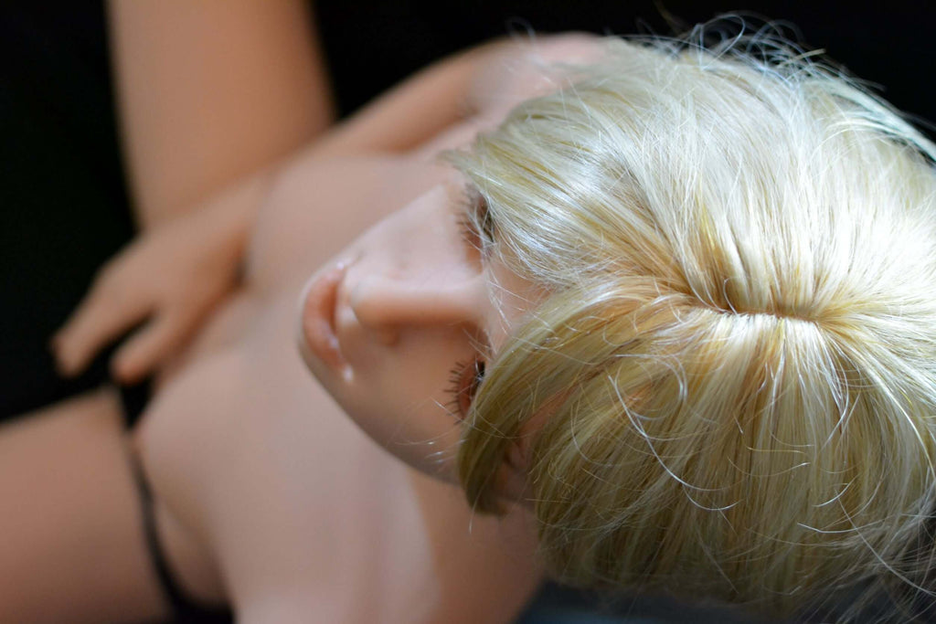 Blonde EscortDoll Chlea mit kleinen, nackten Brüsten in laziver Pose