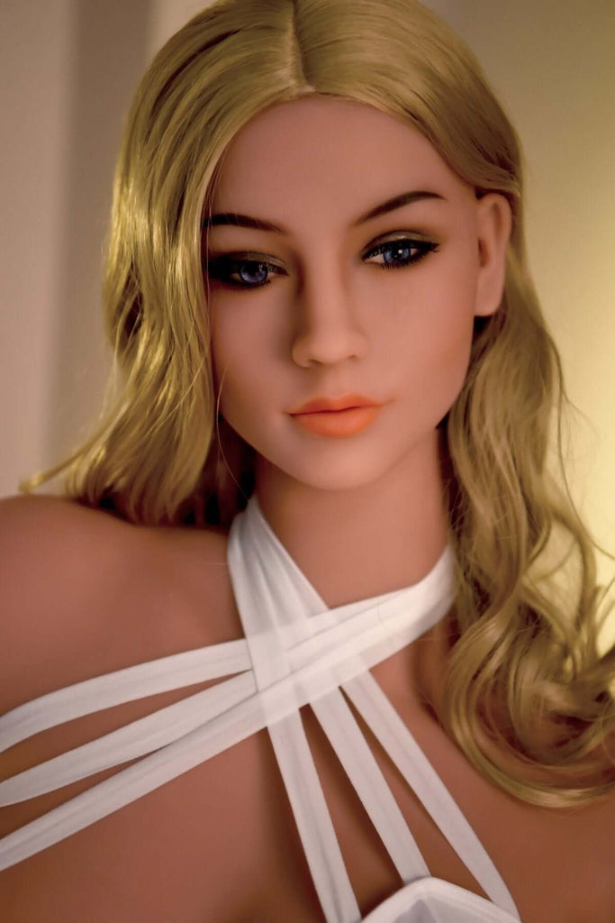Blonde Realdoll Mila mit schönen Brüsten und blauen Augen posiert in Hotelzimmer