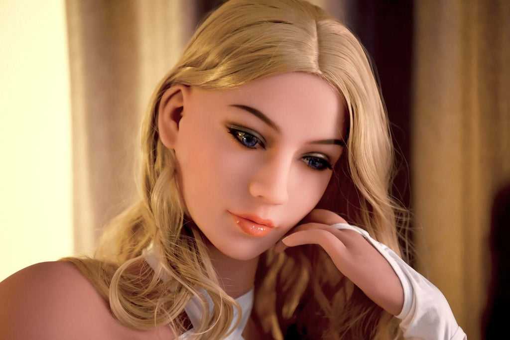 Blonde Realdoll Mila mit schönen Brüsten und blauen Augen posiert in Hotelzimmer